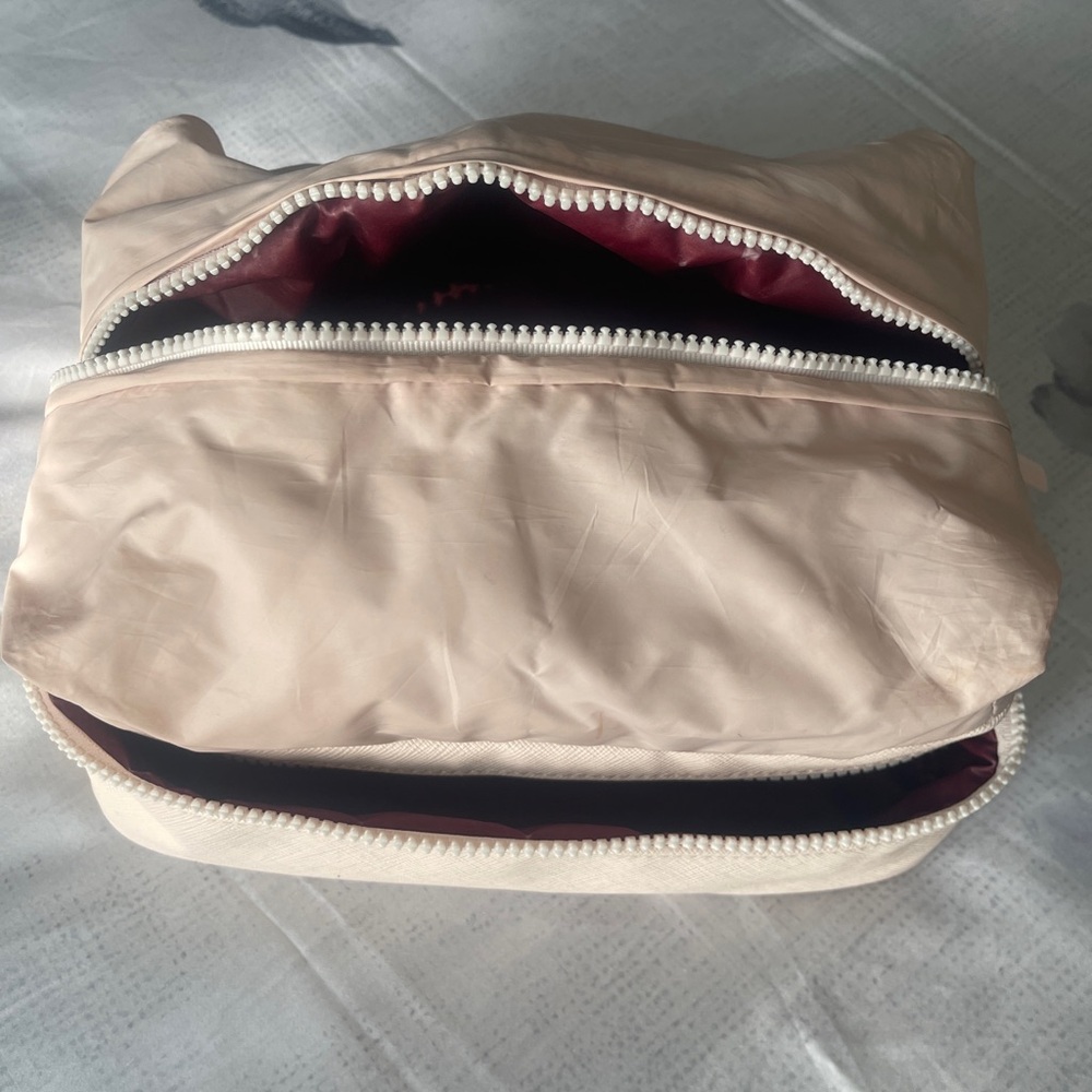 Rare Beauty puffy travel makeup bag in soft peach and burgundy
